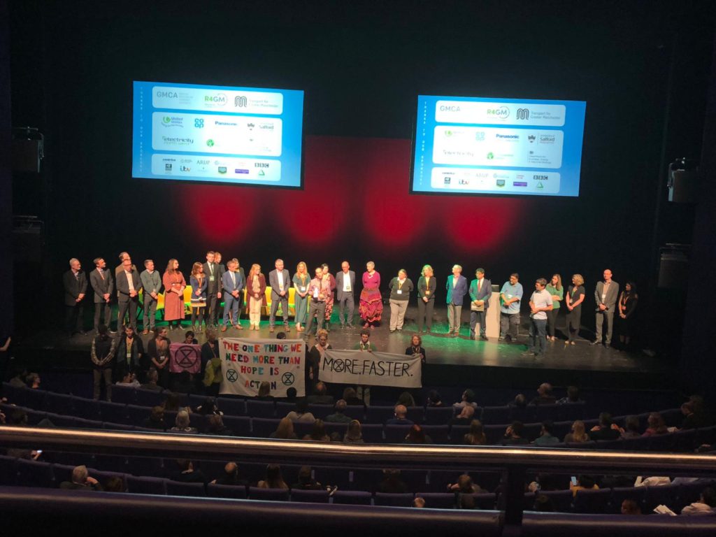 GMCA presents the green summit. An ambitous plan to tackle climate crisis. An Stage with many participants. Extinction Rebellion caused a minor disruption