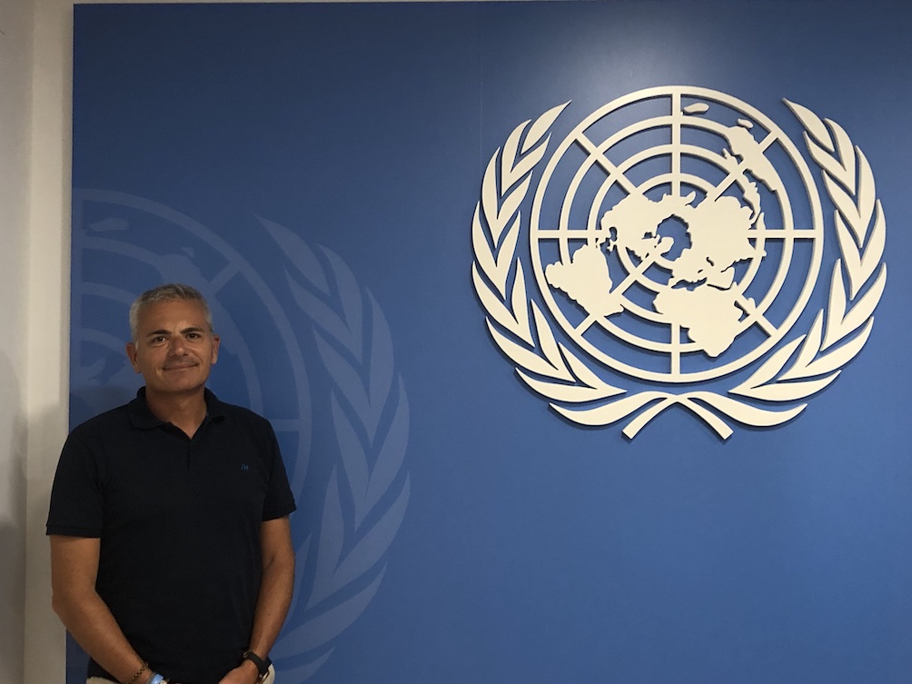 Julio Andrade in front of the UN logo. Julio Andrade is the president of CIFAL Malaga and organisation which form leaders into the UN values. Agenda 2030. Juanele Villanueva